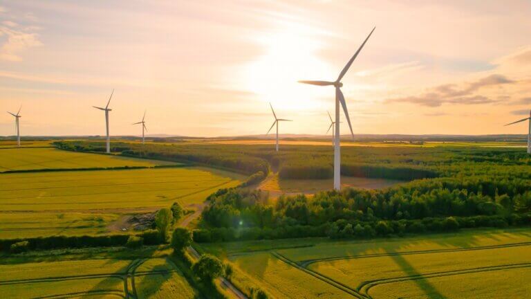 This is an image of wind turbines in front of a flowing sun.