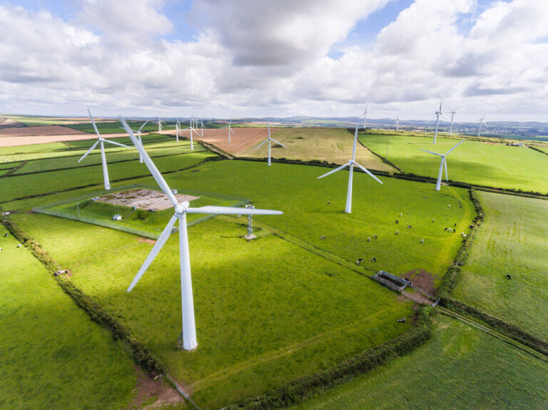 A wind farm across green landscapes.