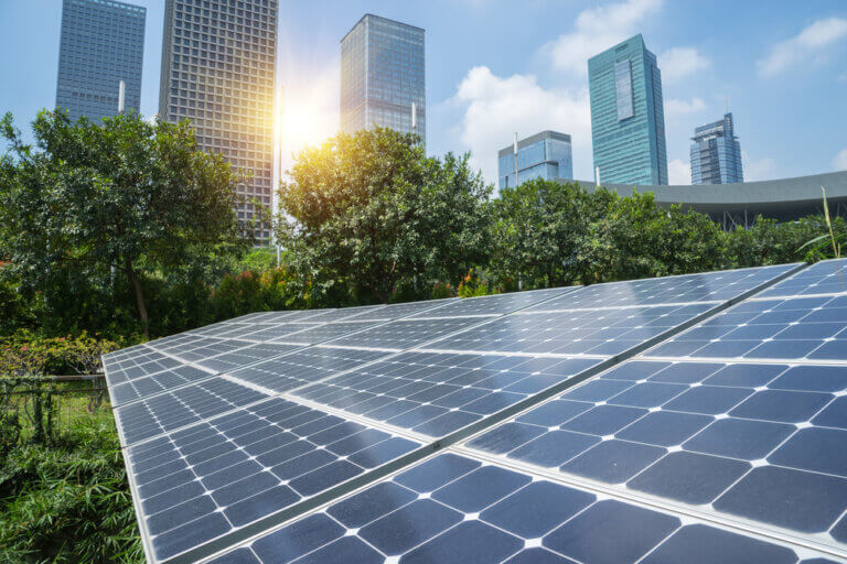 Solar panels and a city background with sunshine.